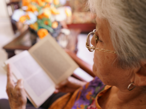 Elderly woman reading book.
